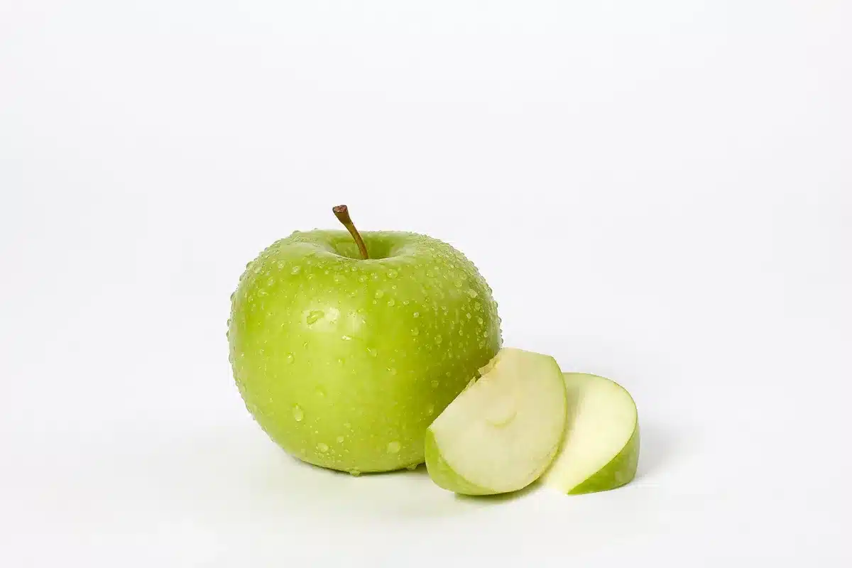 Aufgeschnittene grüne Granny-Smith-Äpfel zeigen das frische, knackige Fruchtfleisch