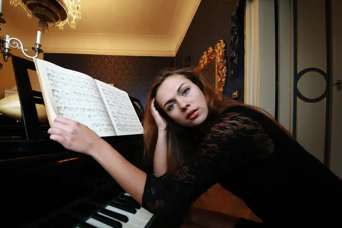 Woman in green dress with ruffles at piano with flowers, evoking country music nostalgia