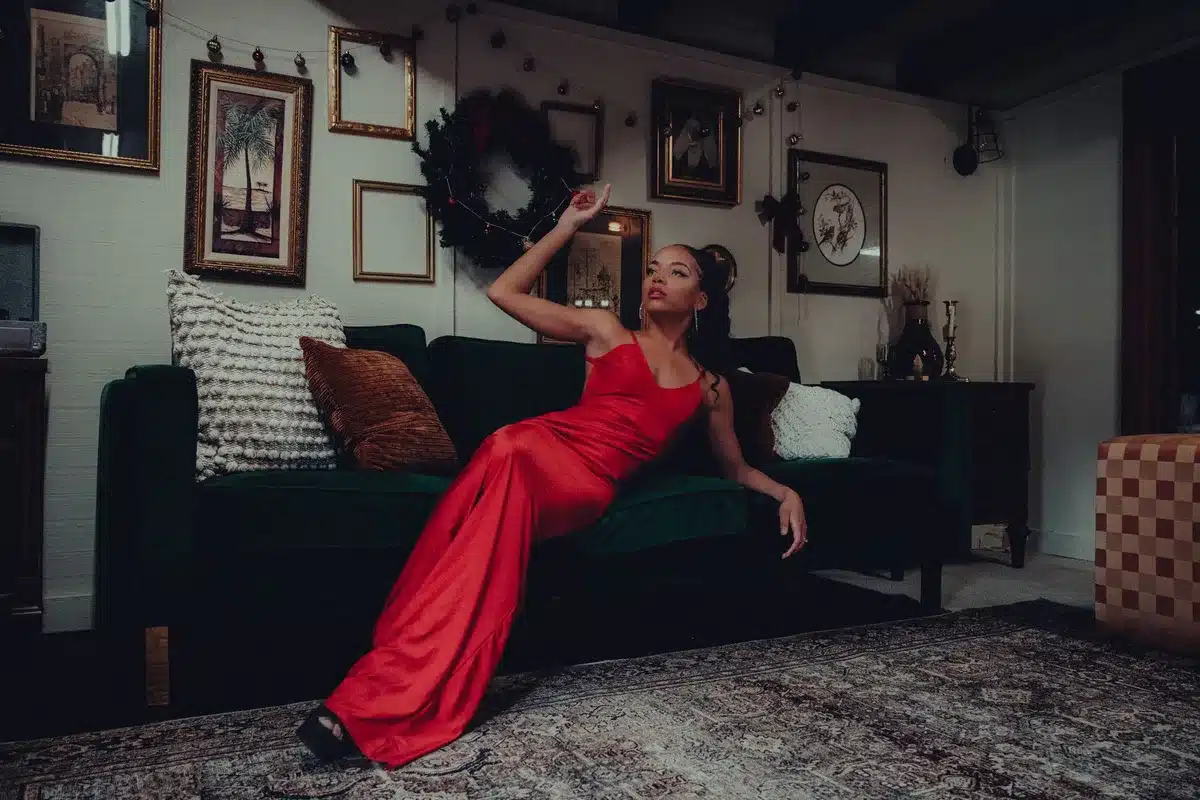 Elegant woman in a flowing satin halter maxi dress on a red carpet premiere event.