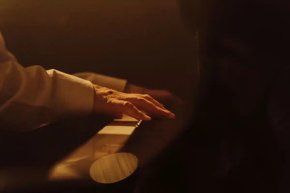 Musiker an einem Klavier mit Hochzeitsring an der Hand