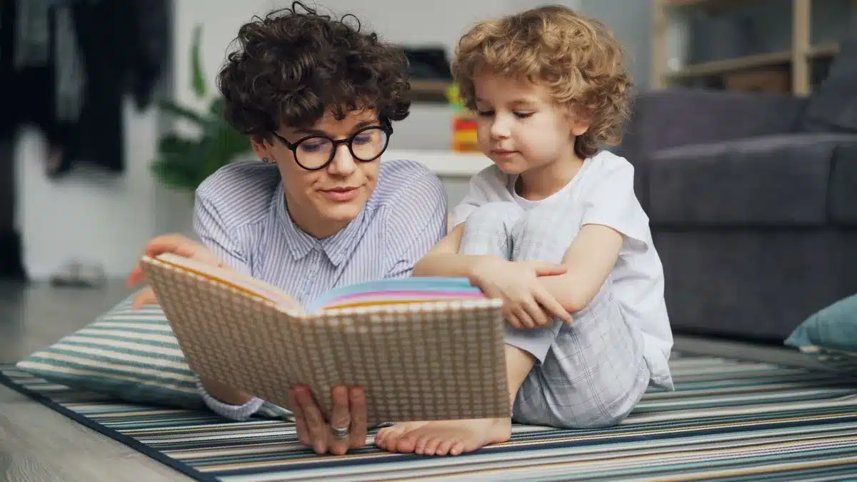 An adult and child reading a book together at home