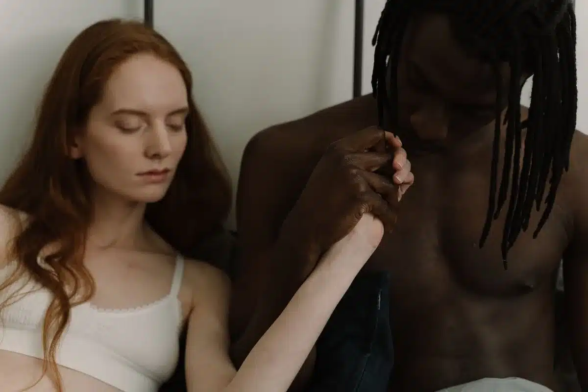 A couple in intimate conversation, holding hands and looking at each other thoughtfully.