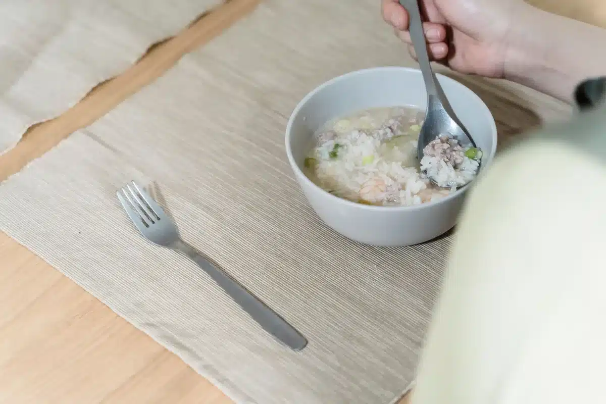 Riz cuit à la vapeur dans un tamis fin, aéré à la fourchette