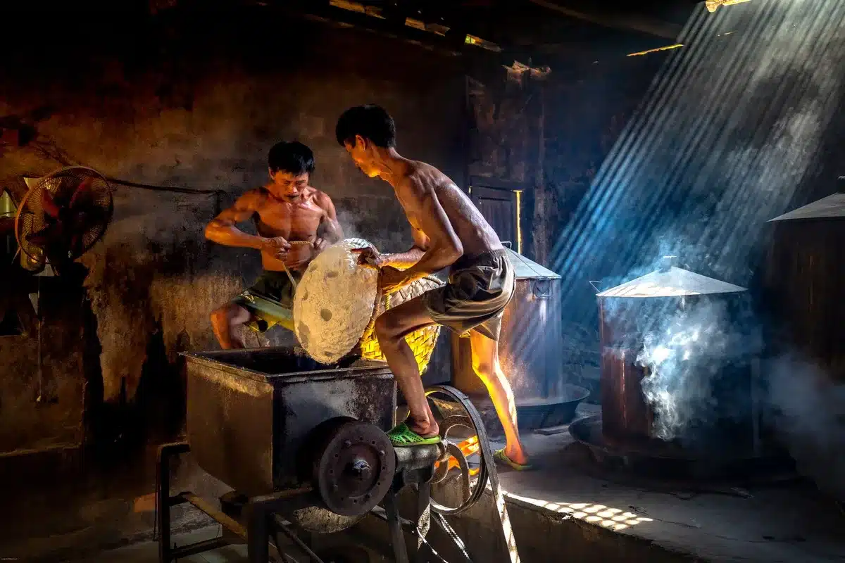 Fine mesh strainer filled with rice suspended over a pot of boiling water, steam rising gently around it