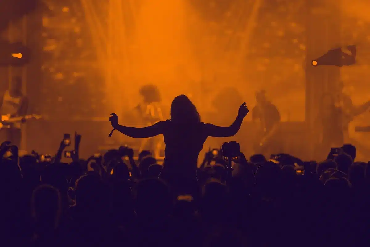 Silhouette of a basketball player holding a trophy with cheering crowd blurred behind