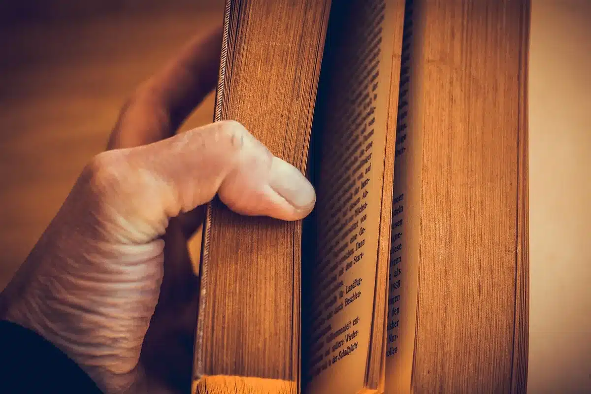An open book on a sofa with a hot coffee mug nearby in a cozy reading nook