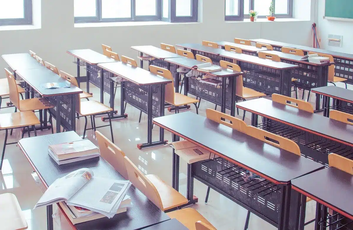 Un bureau d'élève avec cahier ouvert et crayon, lumière de septembre en classe