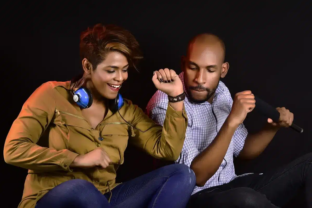 Two people chatting into podcast microphones in an informal setup