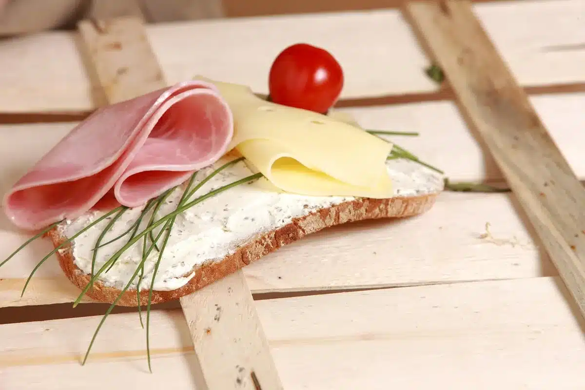 Belegtes Sandwich mit Schinken und Käse auf einem Teller