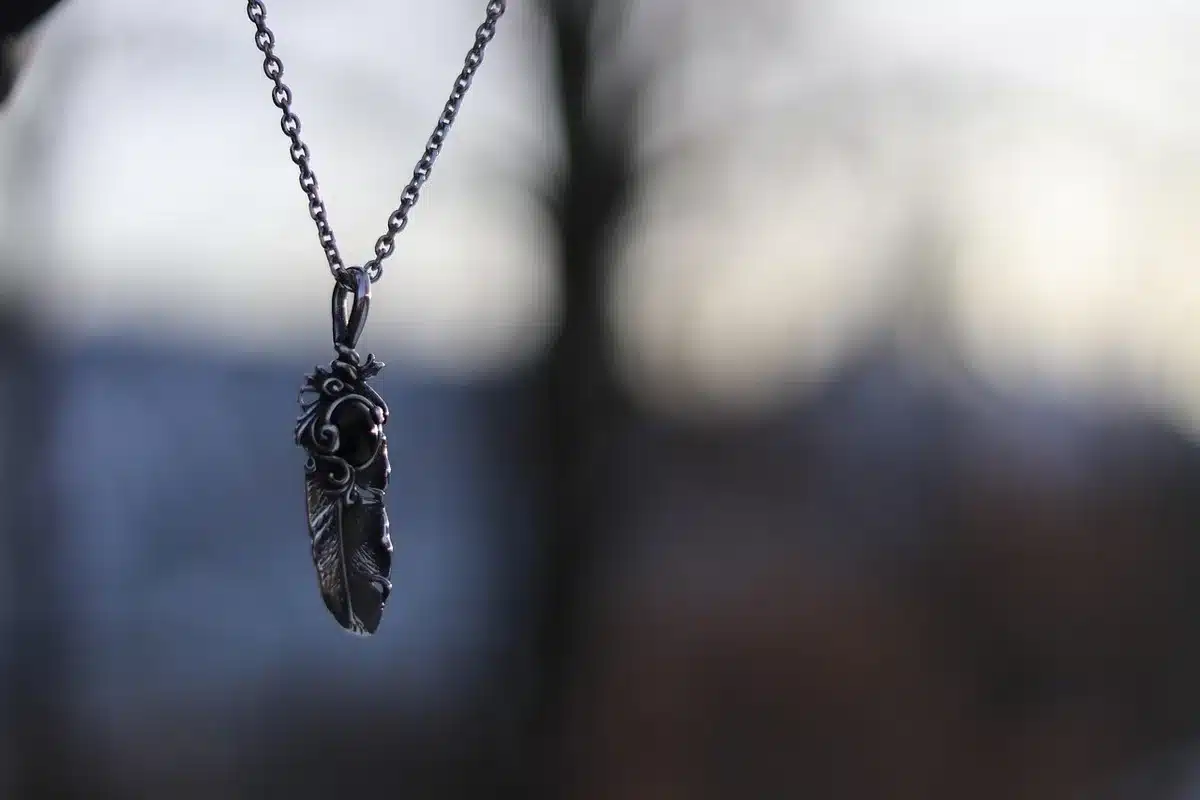 Memento-style gold charm holder necklace on a chain