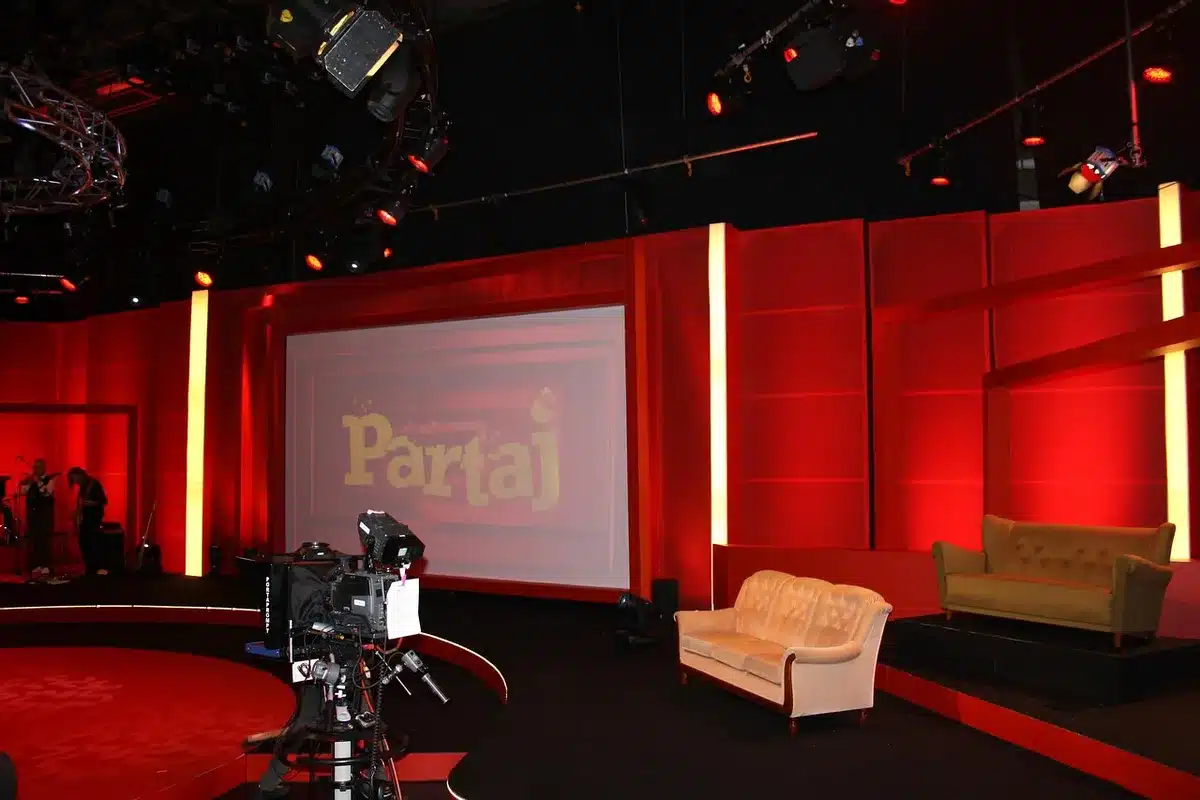 A television studio set with bright lighting and broadcast equipment ready for a live show.