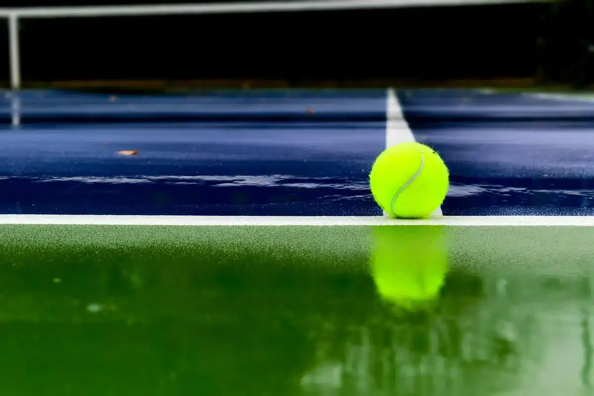 Two tennis players stand ready on court during a professional doubles match at a major tournament.