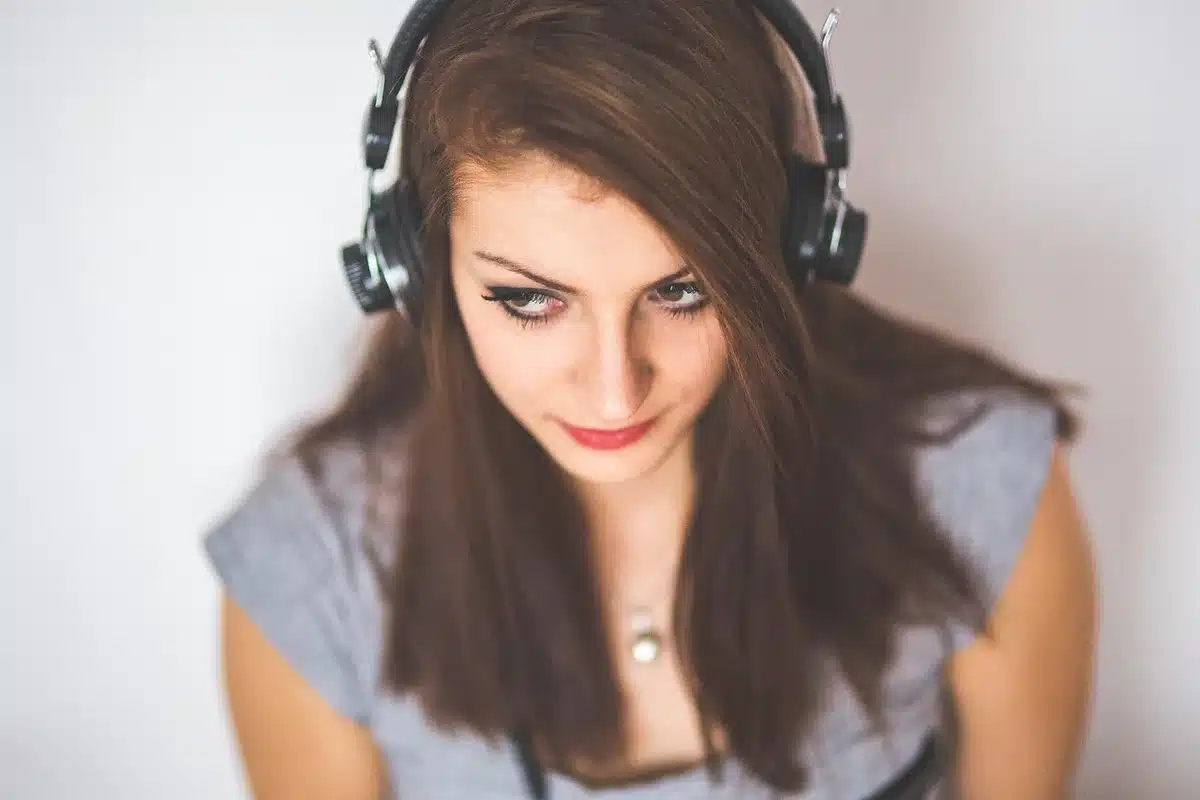 Person with headphones engrossed in an audiobook, tense expression