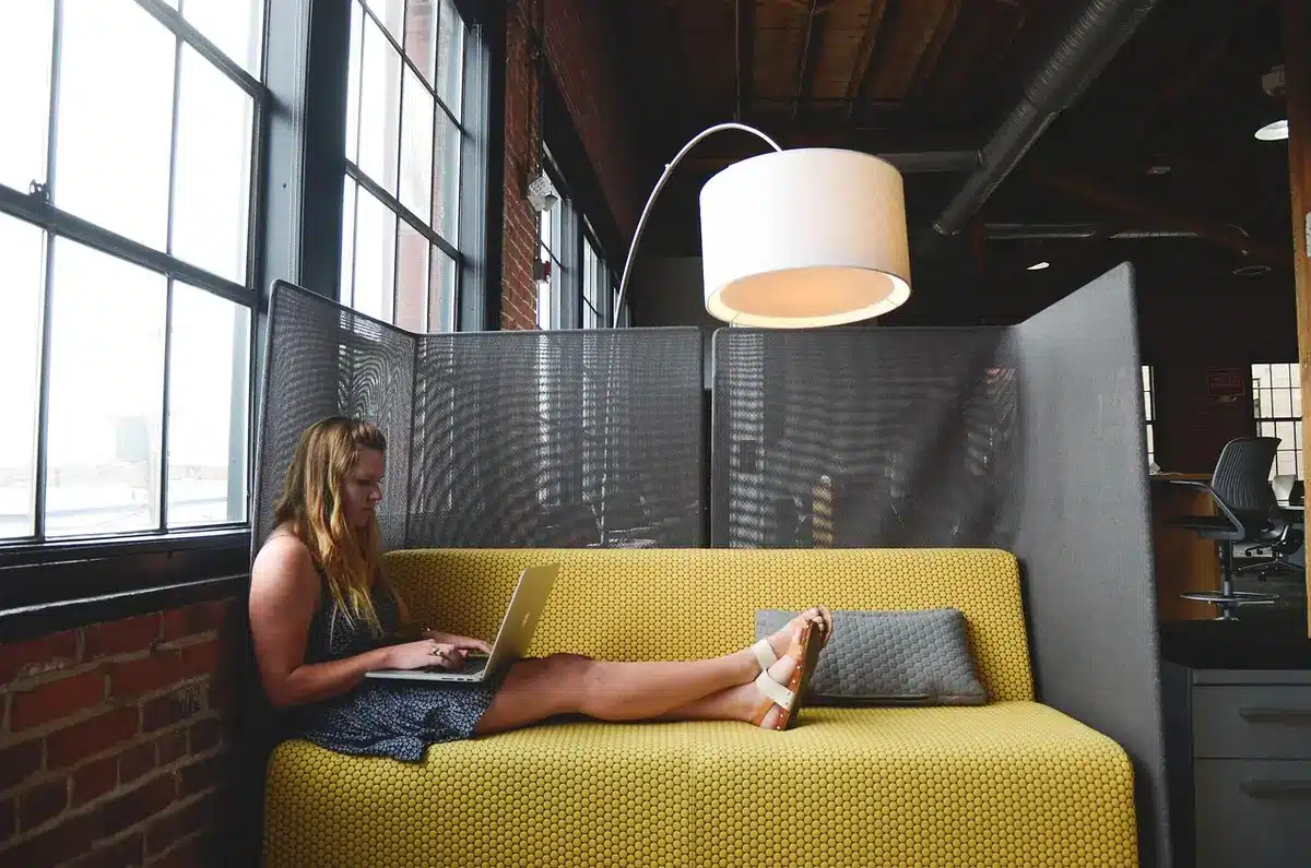 Remote control and TV screen showing streaming app icons on a living room couch