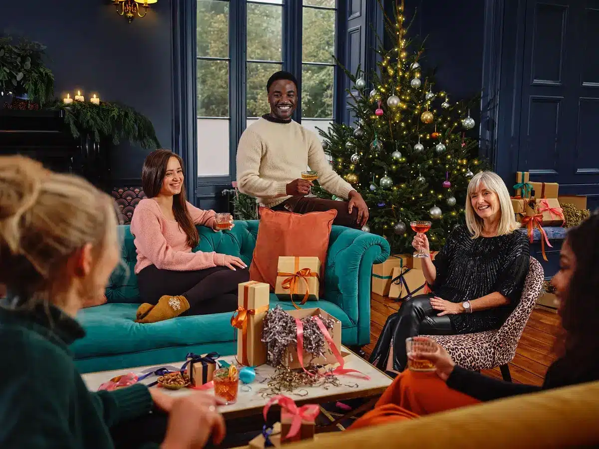 A small group of friends around a living room table with tea and books