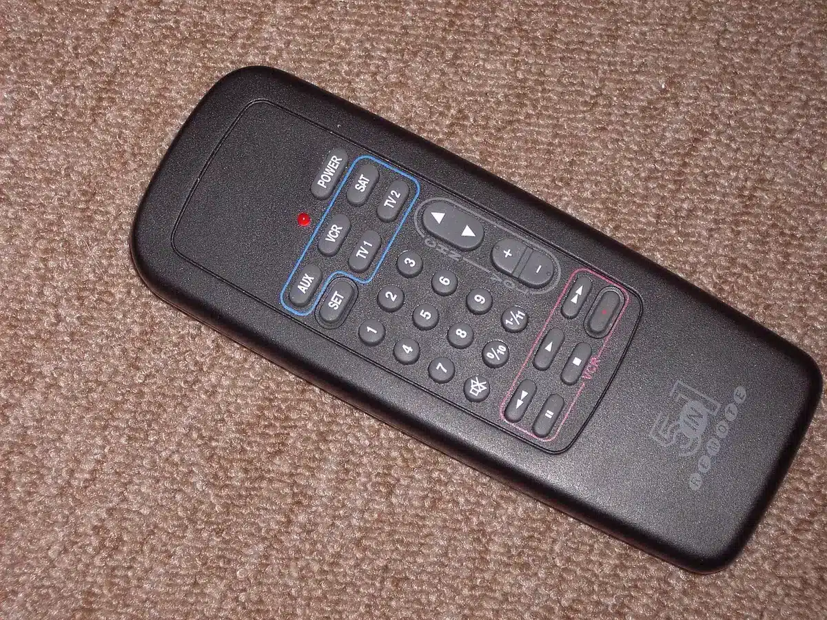 Person holding remote with streaming apps on TV screen
