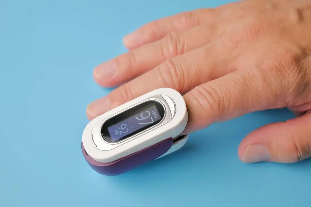 Fingertip dabbing a whipped mousse blush on the back of a hand by a vanity