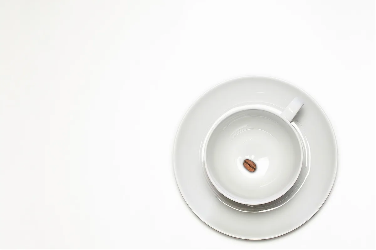 Person sampling coffee during a tasting with score sheets